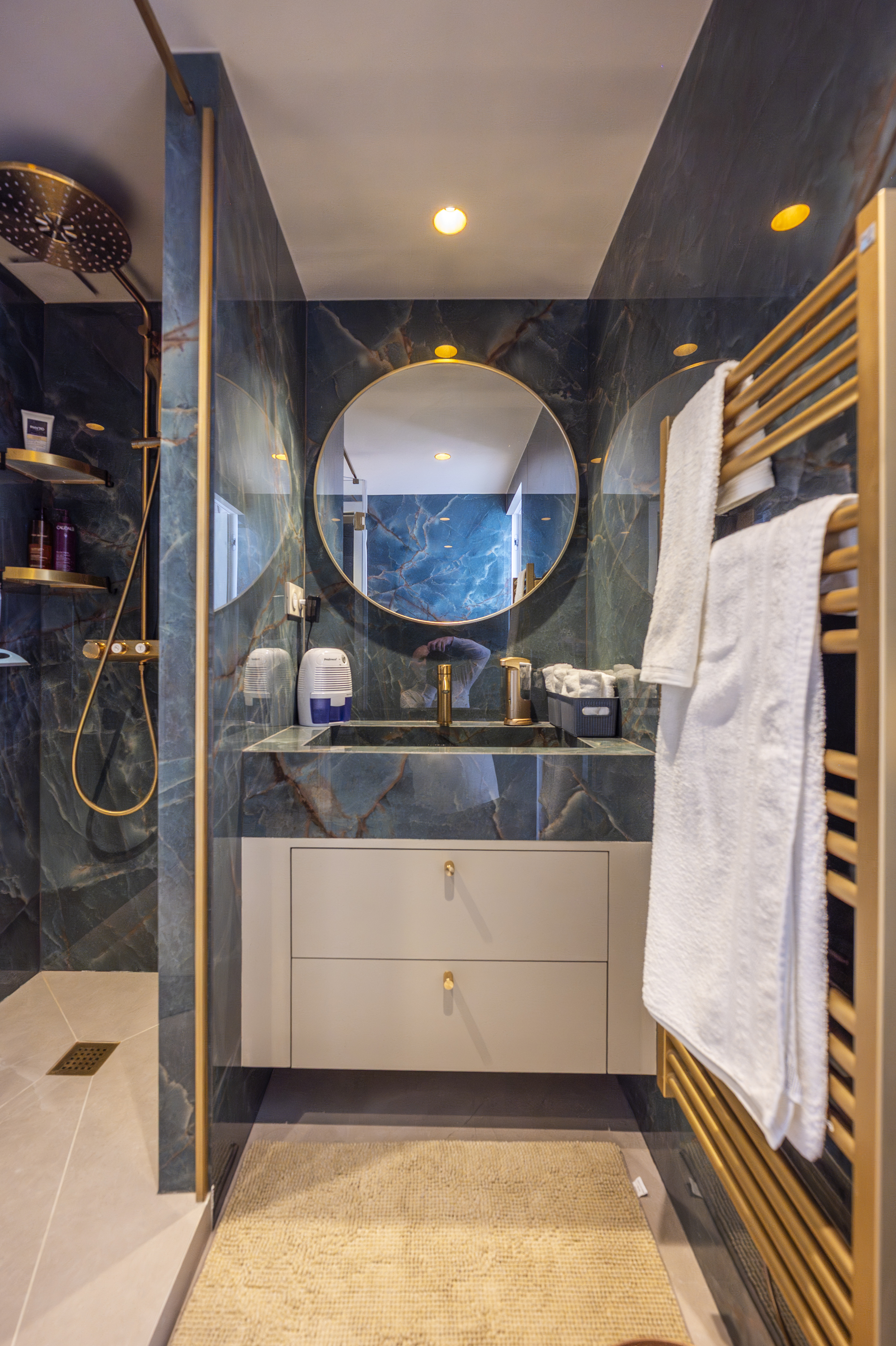 Green marble bathroom with brass fixtures
